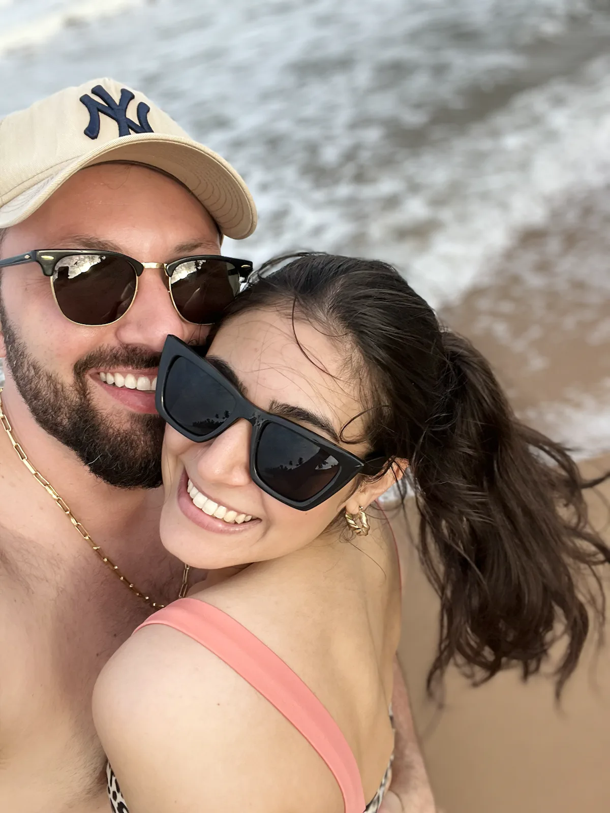 Isabelle e Eduardo sorrindo juntos à beira-mar